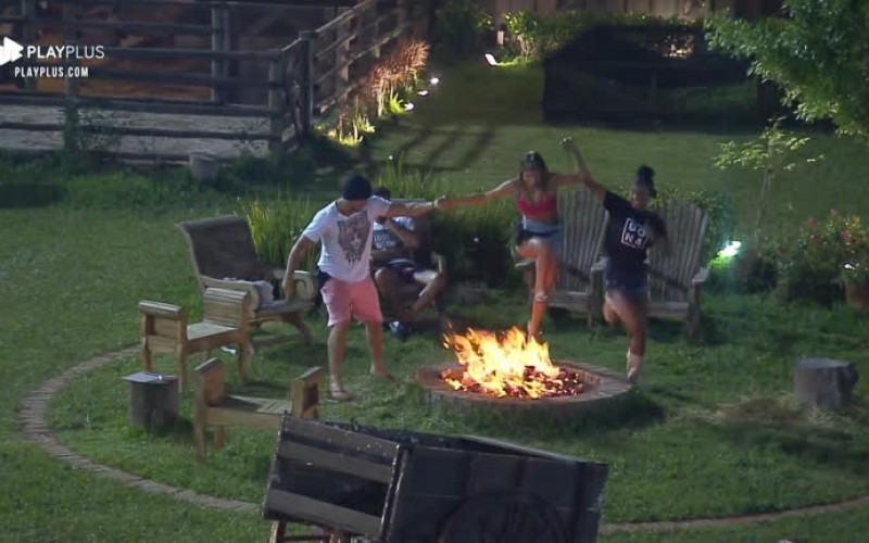 Durante a madrugada, peões brincam de pular fogueira